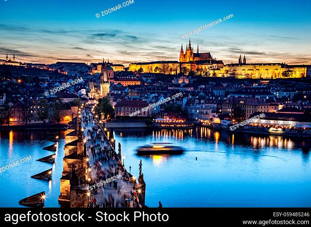 Charles Bridge on Vltava river in Prague, Czech Republic at late sunset, night. View on Prague Castle, Hradcany