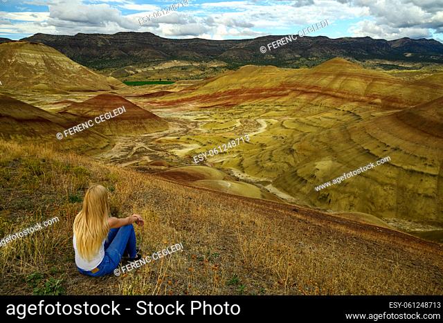 Casual young nature lover woman wonders the bright colors and picture perfect landscape at the Painted Hills Unit - John Day Fossil Beds National Monument