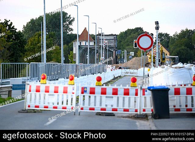 PRODUCTION - 25 September 2022, Schleswig-Holstein, Boren: The construction site barrier next to the temporary station on the closed road in front of the...