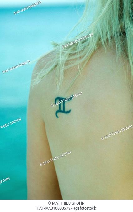 Roman numeral two tattooed on woman's shoulder