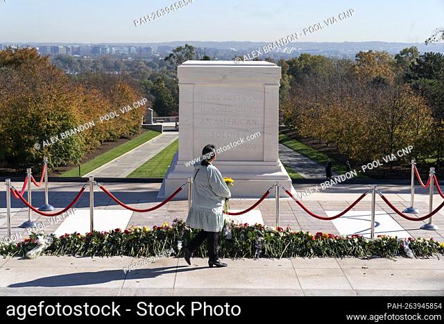 A woman arrives to place flowers during a centennial commemoration event at the Tomb of the Unknown Soldier, in Arlington National Cemetery, Tuesday, Nov