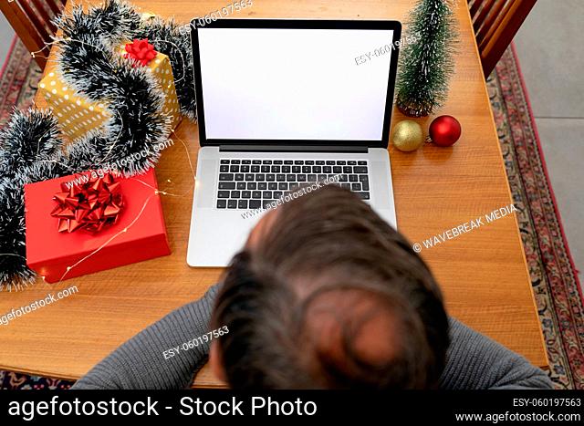 Caucasian senior man having video call on laptop with copy space at christmas time