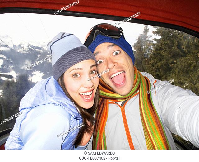 Silly couple laughing in ski lift