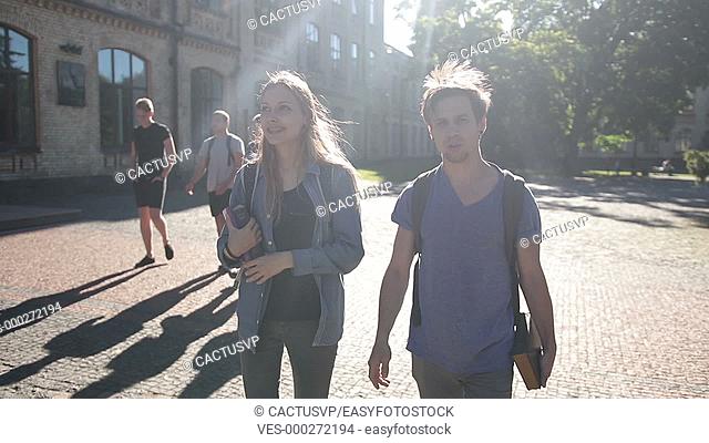 Attractive couple of students walking on campus
