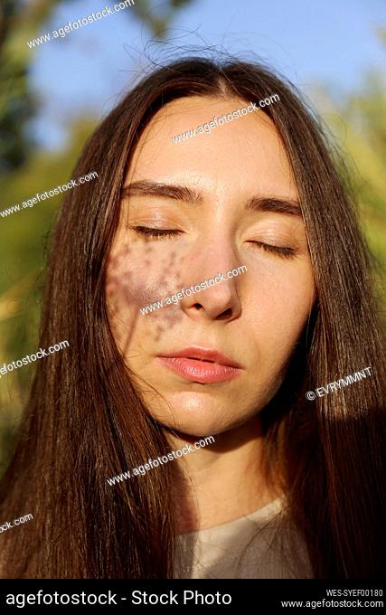 Young woman with flower shadow on face