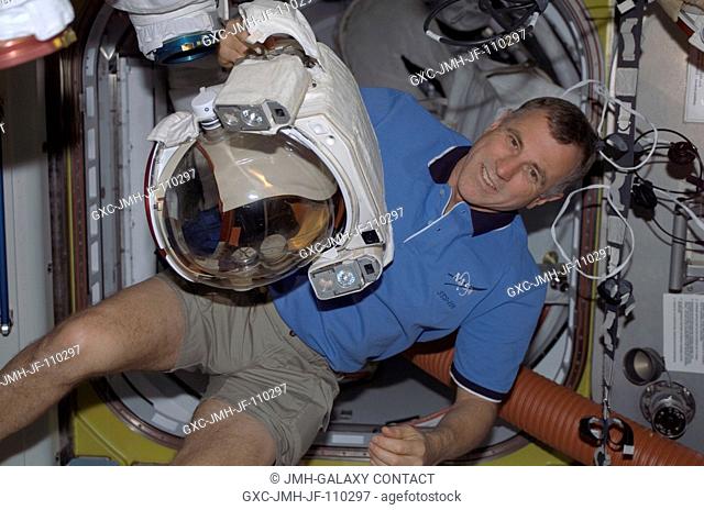 Astronaut Dave Williams, STS-118 mission specialist representing the Canadian Space Agency, holds the helmet for an extravehicular mobility unit (EMU) spacesuit...