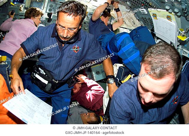 Astronauts Charles J. Camarda, STS-114 mission specialist, and James M. Kelly (right), pilot, assist with rendezvous and docking operations on the flight deck...