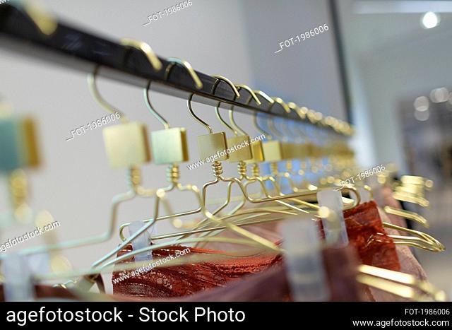 Close up gold lingerie hangers on rack