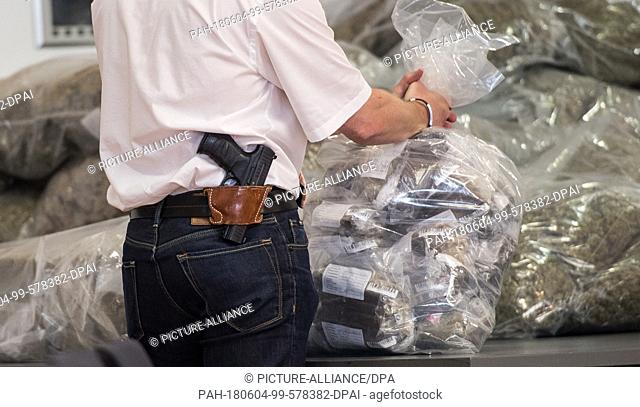 04 June 2018, Germany, Mainz: An investigating officer holding a sack of drugs. The joint drugs investigation group of the Federal Police and German Customs at...