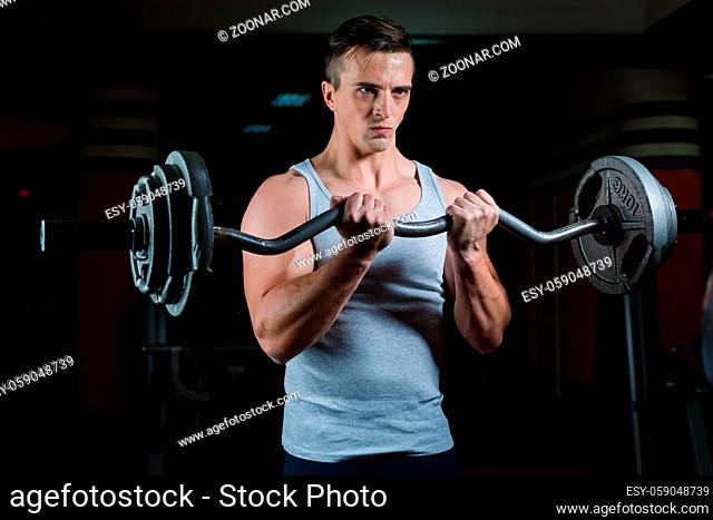 Closeup portrait of a muscular man workout with barbell at gym. Deadlift barbells workout