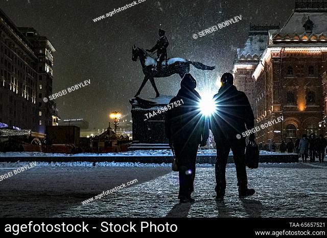 RUSSIA, MOSCOW - DECEMBER 11, 2023: Citizens walk past a monument to Soviet Marshal Georgy Zhukov (1896-1974) in Manezhnaya Square