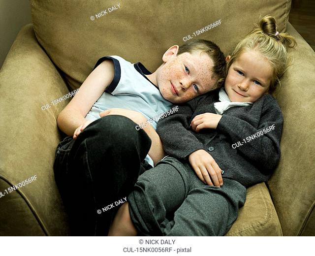 A brother and sister in an arm chair
