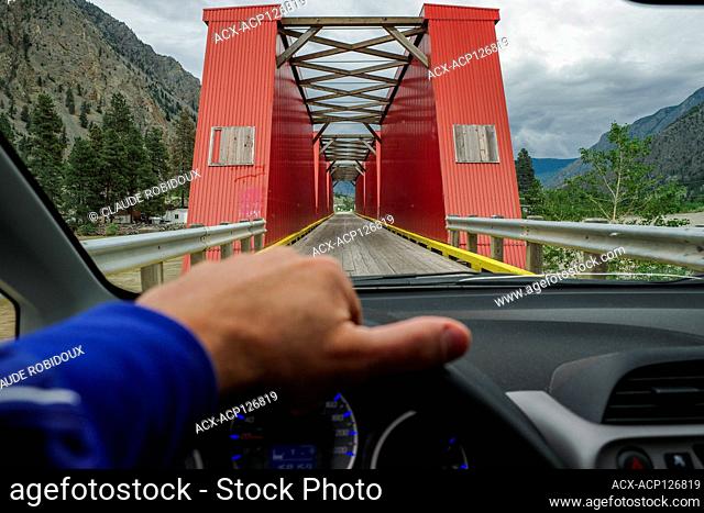 Driving on the single lane on the old historic red bridge, Similkameen River Bridge No. 6, in Keremeos, British Columbia, Canada