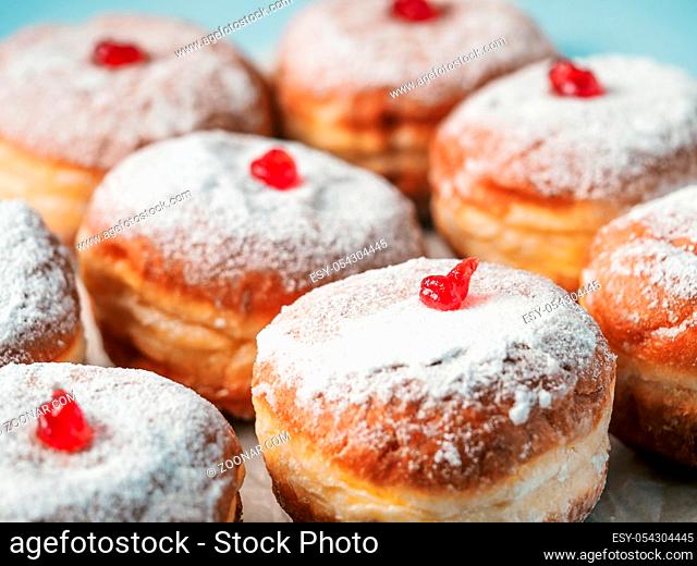 Hanukkah food doughnuts with jelly and sugar powder on blue background. Jewish holiday Hanukkah concept and background. Copy space for text