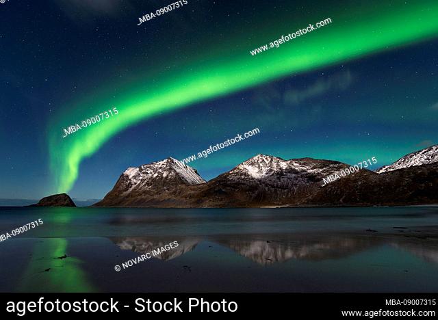 Northern Lights as a closed band over the summit of Mannen and Haukland Strand, Lofoten, Nordland, Norway