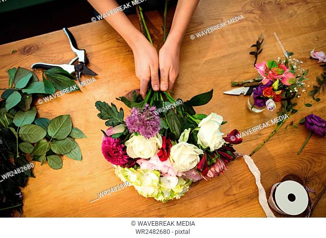 Female florist preparing a flower bouquet at her flower shop