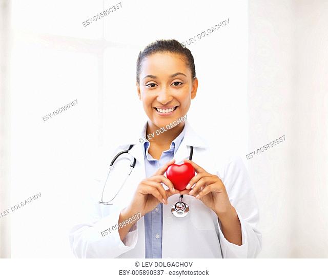 healthcare, medical and cardiology concept - african female doctor with heart