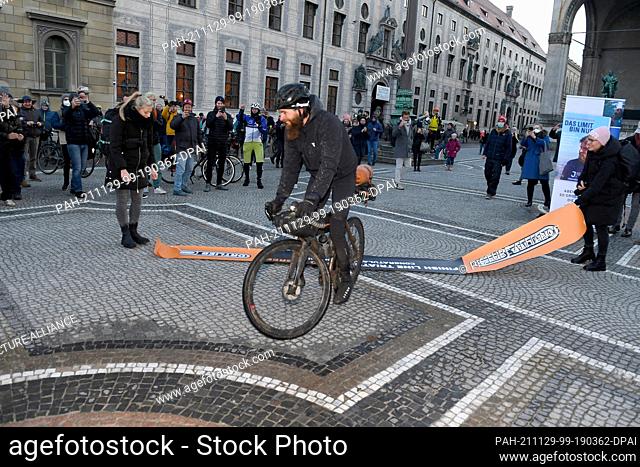29 November 2021, Bavaria, Munich: German extreme athlete Jonas Deichmann rides to the finish of his triathlon around the world at Odeonsplatz