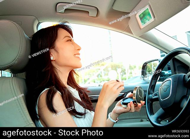A beautiful young woman makeup in the car