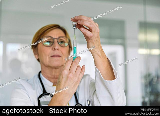 Doctor preparing a vaccine for patient