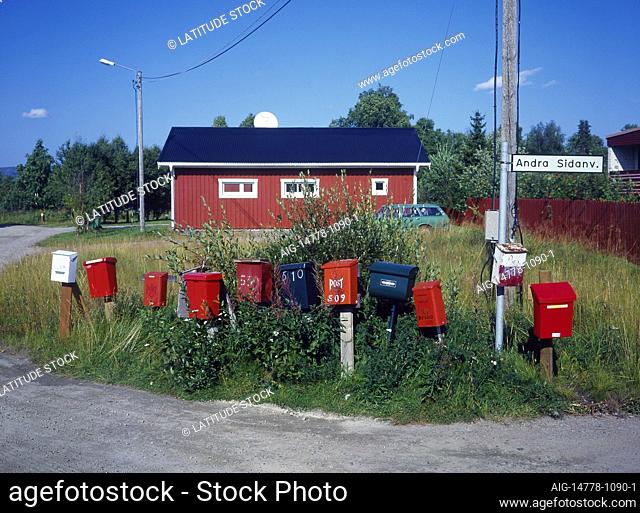 Private letter boxes on street corner. Grass. Building behind