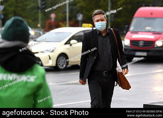 12 October 2021, Berlin: Robert Habeck, federal chairman of Bündnis 90/Die Grünen, arrives at the venue for the exploratory talks and is welcomed by Greenpeace...