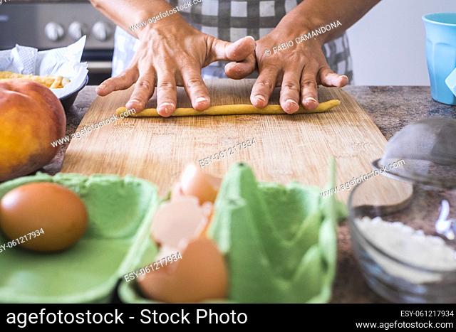 Close up of woman at home preparing and cooking hand made pasta on the table - concept of work indoor house activity for wife or single female - healthy food...