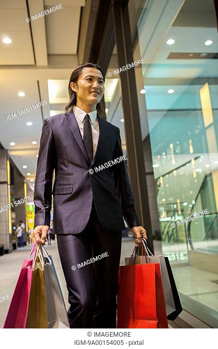 Business man shopping, holding many shopping bags