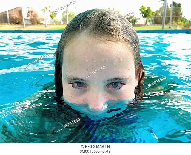 Portrait of a half submerged girl in a swimming pool