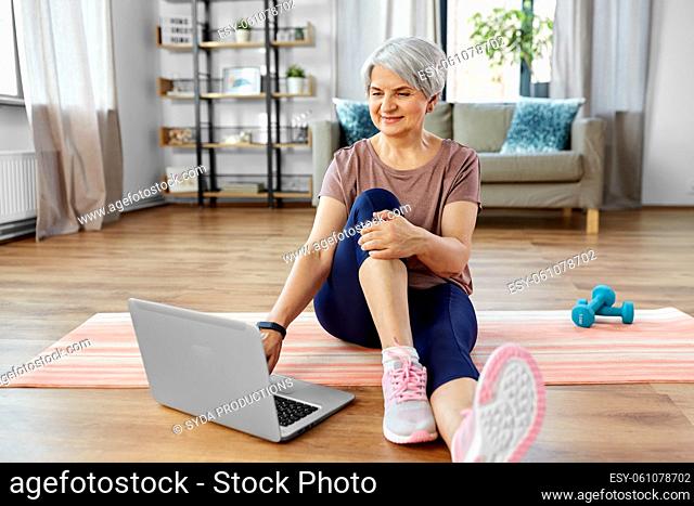happy woman with laptop exercising at home