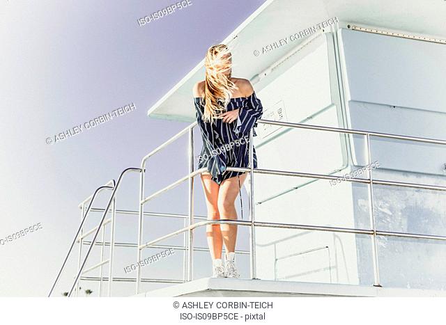 Woman relaxing on lifeguard tower