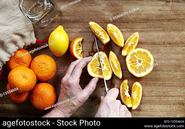 Man cutting oranges for marmalade, Southend-on-sea, Essex, England, UK