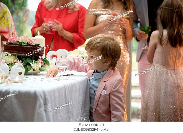 Boy curious about gifts and cake at wedding reception