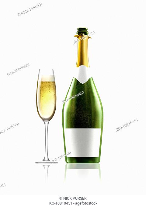 Glass of champagne next to champagne bottle with white label