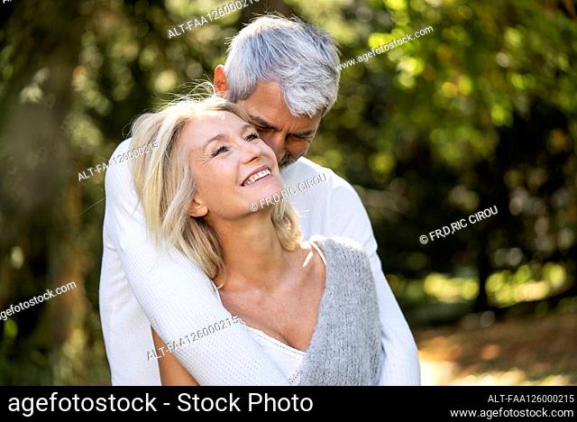 Happy mature couple embracing each other in backyard