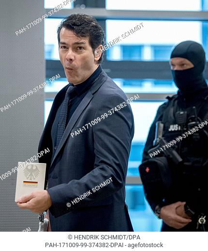 Former ""Mister Germany"", Adrian Ursache (L), showing the Basic Law (German Constitution) ahead of the start of his trial in a hall of the District Court in...