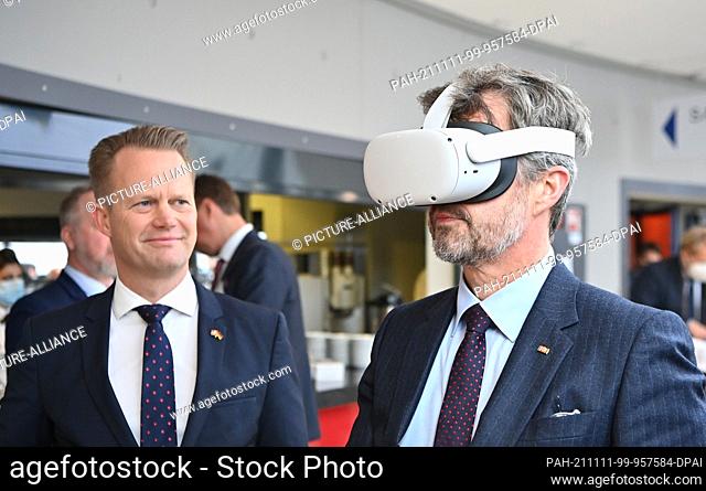11 November 2021, Berlin: Crown Prince Frederik (r) wearing virtual reality goggles and Jeppe Kofod, Foreign Minister of Denmark