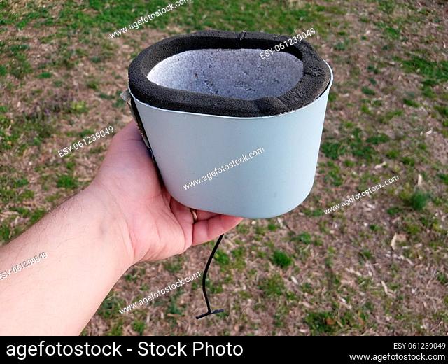 hand holding water spigot insulation cap or cover over grass or lawn