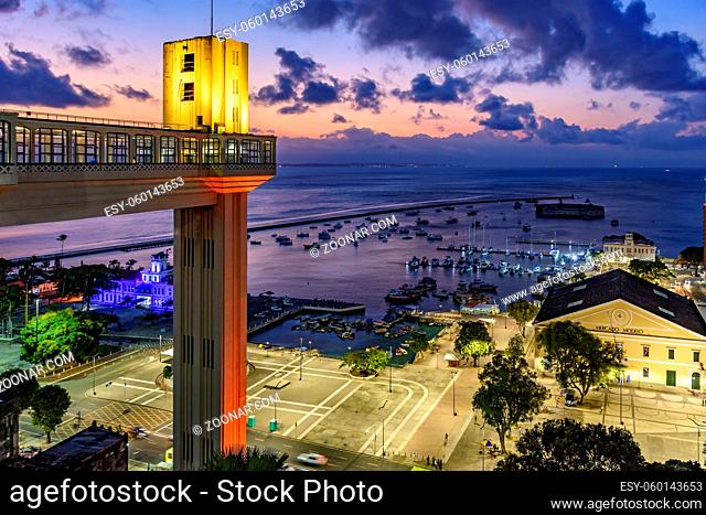 Lacerda elevator illuminated at dusk and with the sea and boats in the background in the city of Salvador, Bahia
