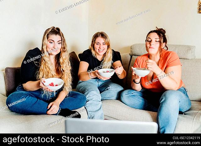 Young women eating together on video call