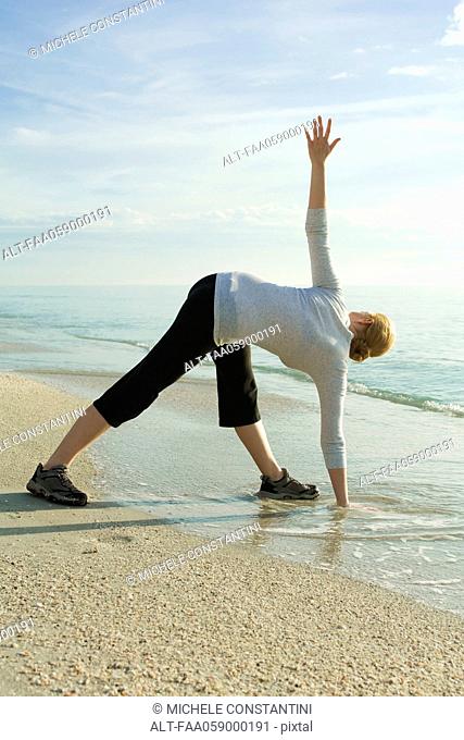 Woman doing yoga at the beach