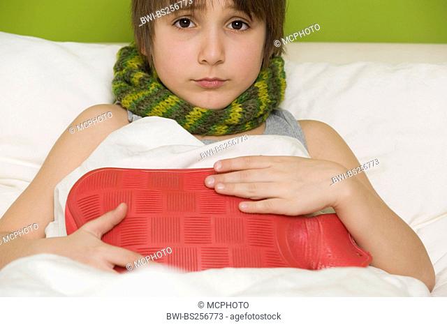 sick boy with hot-water bottle in bed