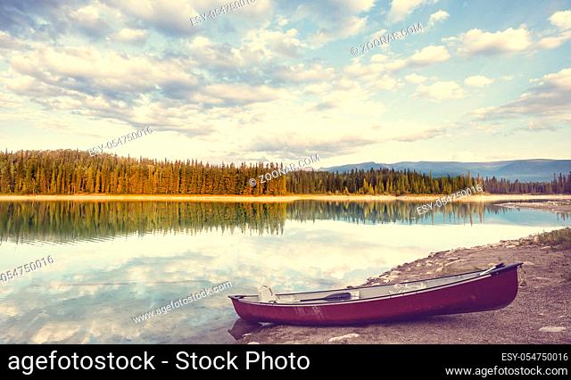 Serene scene by the mountain lake in Canada with reflection of the rocks in the calm water