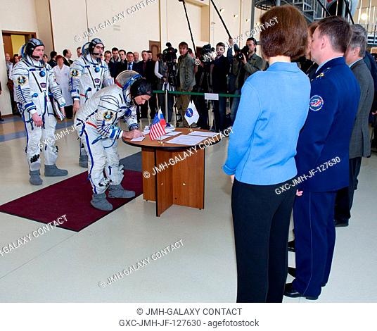 Expedition 31 NASA backup crew member Kevin Ford signs for his Soyuz vehicle simulation test card before senior officials at the Gagarin Cosmonaut Training...