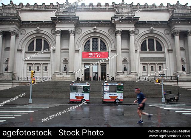 09 April 2020, US, New York: A jogger is running on the empty street in front of the entrance to the Metropolitan Museum