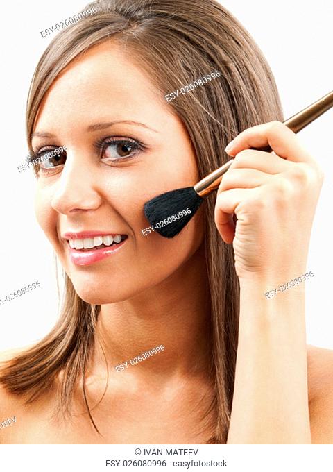 Close up of young woman face, holding a make up brush in one hand