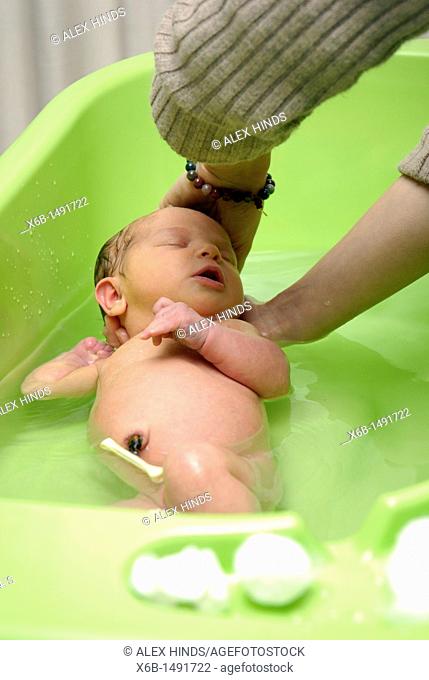A newborn baby being bathed