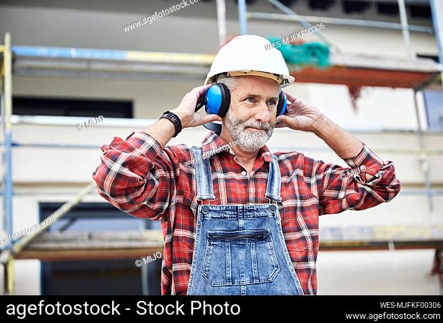 Construction worker with ear muff working at construction site
