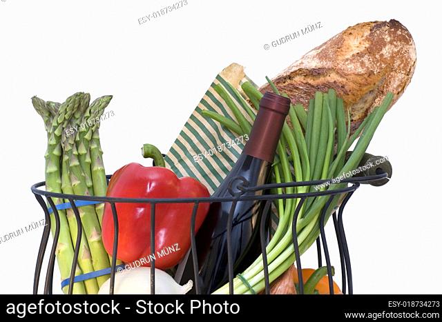 Basket full of fresh products with bread and a wine bottle