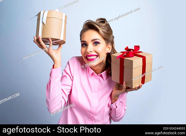 Young happy woman holding two presents with bows